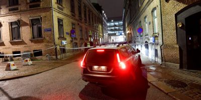 A police car parked outside a brick building late at night.