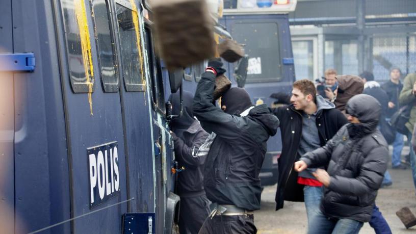 Rioters attack a police picket truck in Malmö, Sweden.